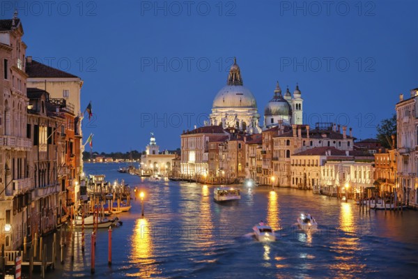 View of Venice Grand Canal with boats and Santa Maria della Salute church in the evening from Ponte