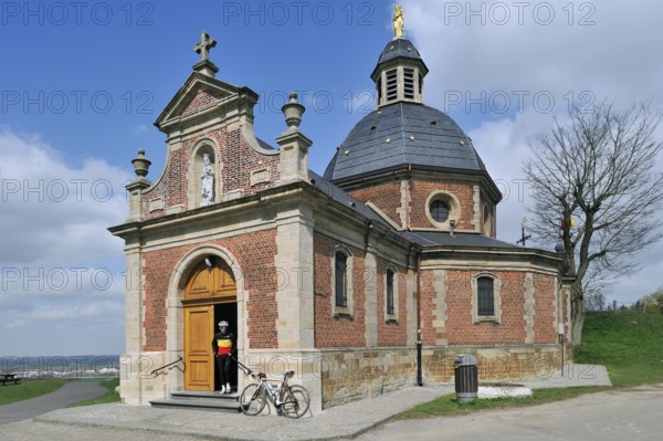Cyclists leaving the chapel of Our Lady of the Old Mountain on the Muur van Geraardsbergen,