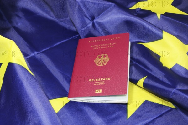 Symbolic image of freedom to travel: German passport on a European flag