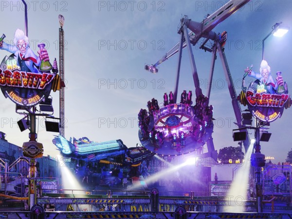 People on the illuminated carousel Mr Gravity in the evening, Cranger Kirmes, Herne, Ruhr area,