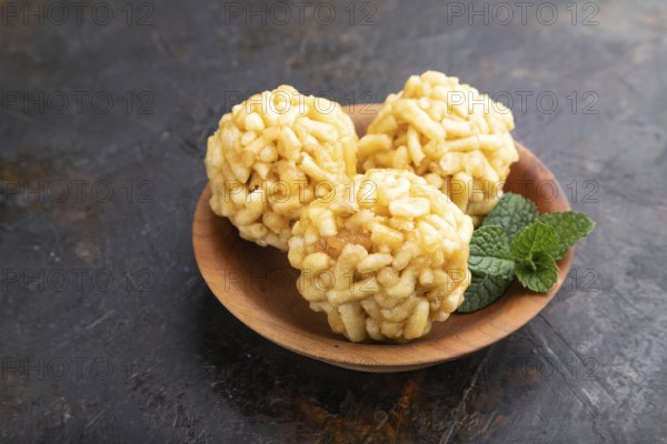 Traditional Tatar candy chak-chak made of dough and honey in wooden plate on a black concrete