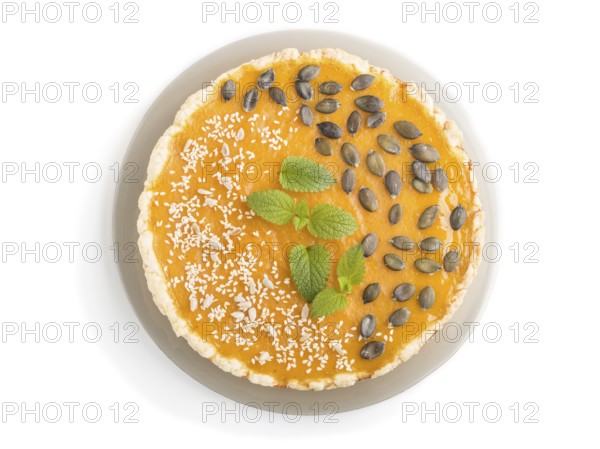Traditional american sweet pumpkin pie decorated with mint, sesame and pumpkin seeds isolated