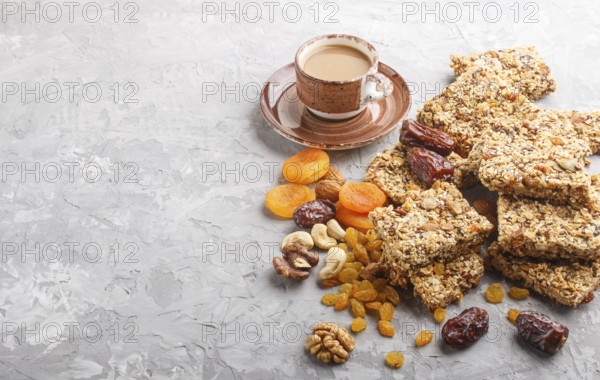 Homemade granola from oat flakes, dates, dried apricots, raisins, nuts with a cup of coffee on a