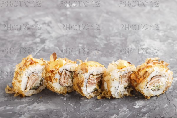 Japanese maki sushi rolls with tuna, cucumber, cheese on black concrete background. Side view,