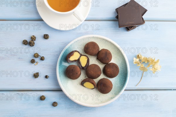 Japanese rice sweet buns chocolate mochi filled with cream and cup of green tea on blue wooden