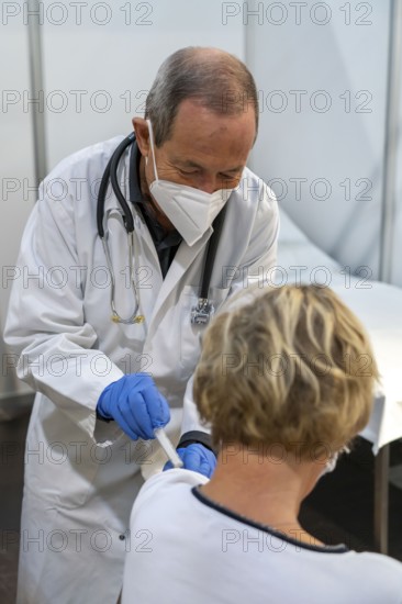 Vaccinator administers a vaccination, during the test run in the vaccination centre for corona