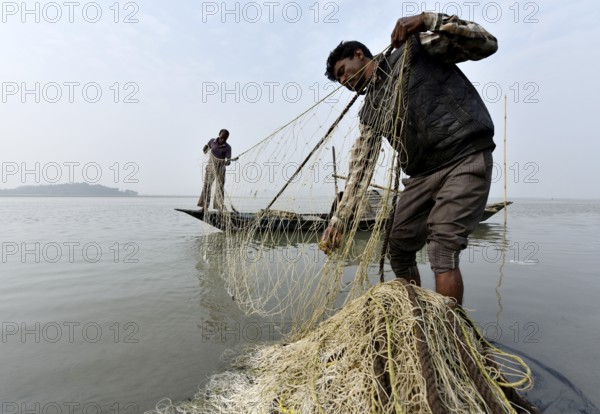 Fisherman cleaning plastics and other materials from their fishing net after fish in the