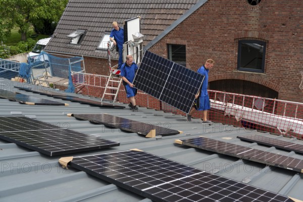 Installation of solar modules on the roof of a barn on a farm, over 240 photovoltaic modules are