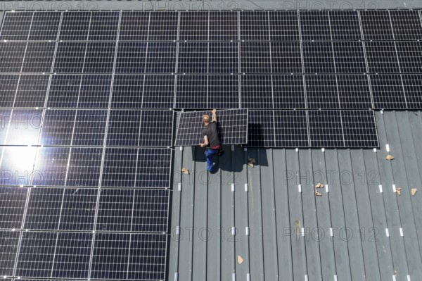 Installation of solar modules on the roof of a barn on a farm, over 210 photovoltaic modules are
