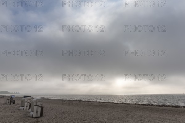 Rain clouds over the Flensburg Fjord, empty beach at Drei, beach chairs, Holnis peninsula, sunlight