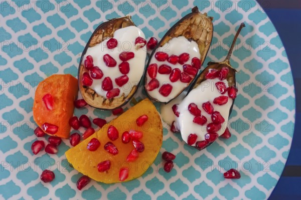 Mediterranean cuisine, roasted aubergines with pomegranate seeds and yoghurt, sweet potatoes,
