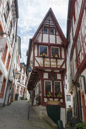 Half-timbered house in a narrow old town street with floral decorations and romantic atmosphere,