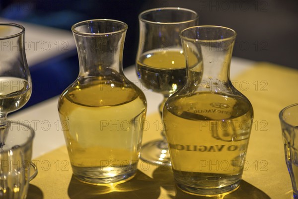 White wine in two small carafes and a glass on the table of a restaurant, Genoa, Italy, Europe