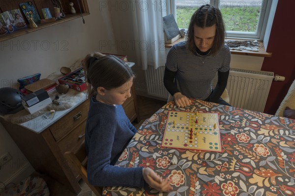 Two sisters playing the parlour game Mensch Ärgere Dich nicht, Mecklenburg-Vorpommern, Germany,