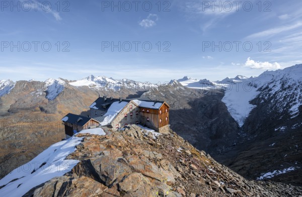 Snowy mountain landscape, mountain hut Ramolhaus in autumn with snow, in the evening light, view of