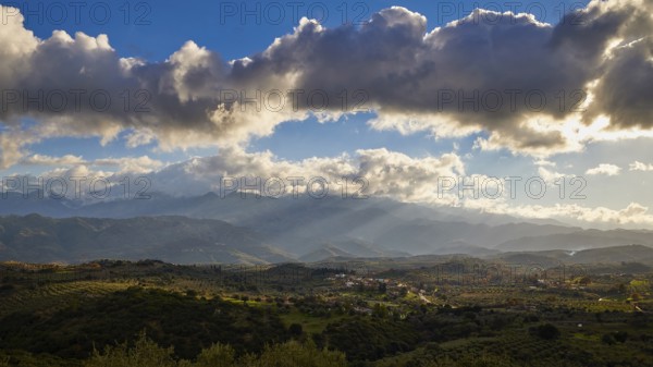 Green landscape with hills under a sunny sky with clouds, Lefka Ori, White Mountains, Mountain