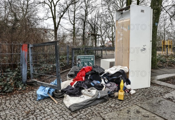 Clothing, a warning light and a refrigerator block the entrance to a public playground, illegal