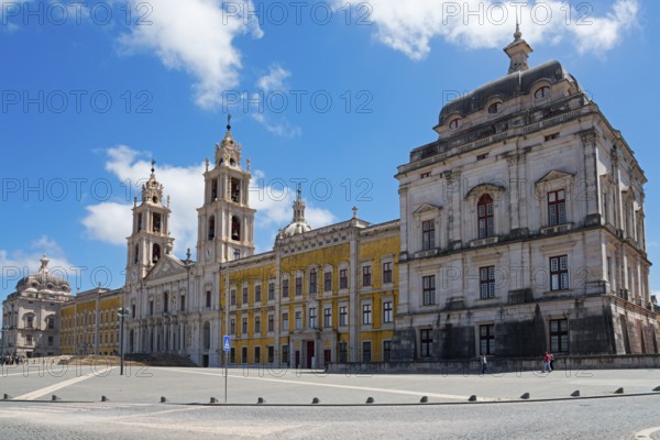 Spacious square in front of a magnificent baroque palace with towers under a blue sky, National