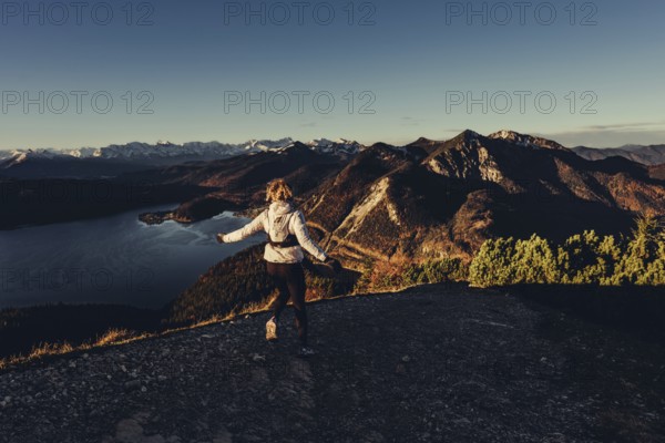 Trail running in autumn on the Jochberg on Lake Walchensee against the wonderful backdrop of the