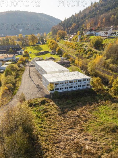 Warehouses surrounded by autumnal forest and village houses, refugee accommodation Beermiß,