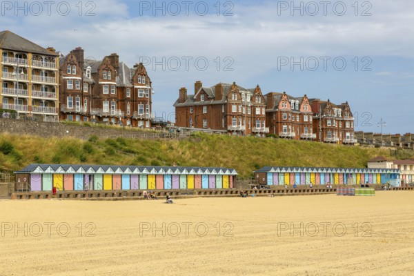 Colourful beach huts and historic clifftop buildings, South Beach, Lowestoft, Suffolk, England, UK