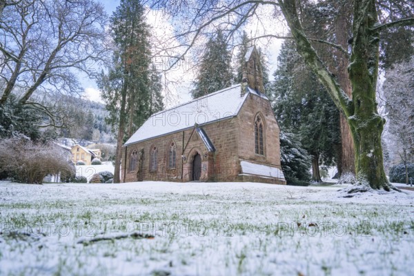 A snow-covered church embedded in a wintry landscape, spa garden, English Church, Bad Wildbad,