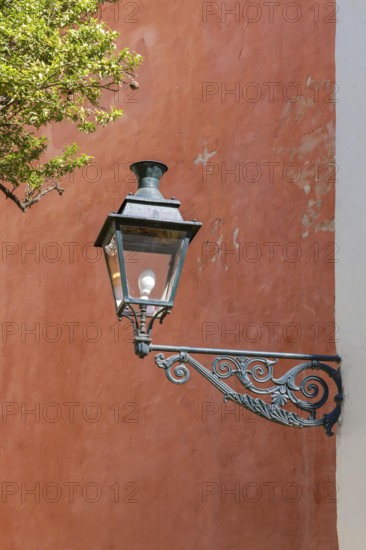 Lantern in front of a red house wall, Seville, Andalusia, Spain, Europe