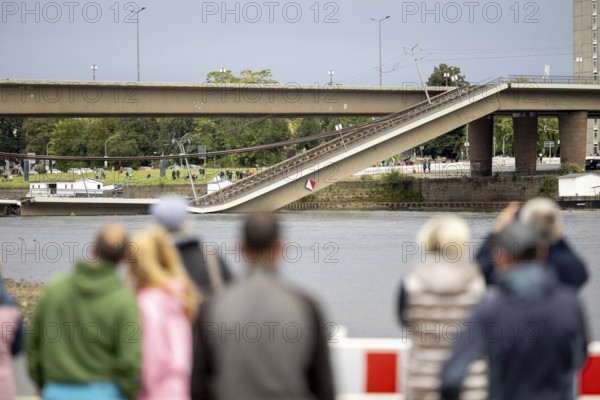 Passers-by look at the partially collapsed Carola Bridge from the Königsufer in Dresden, 11/09/2024