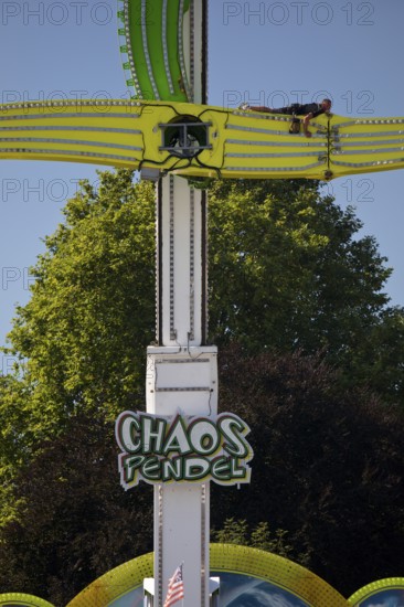 An employee works at the Chaos Pendulum ride at a dizzying height, Cranger Kirmes, Herne, Ruhr