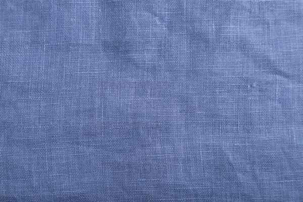 Fragment of smooth blue linen tissue. Top view, flat lay, natural textile background and texture