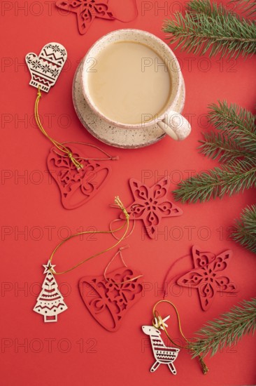 Christmas or New Year composition. Decorations, fir and spruce branches, cup of coffee, on a red