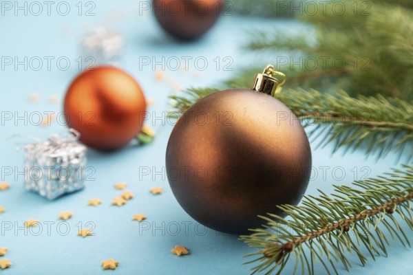 Christmas or New Year composition. Decorations, bronze balls, fir and spruce branches, on a blue