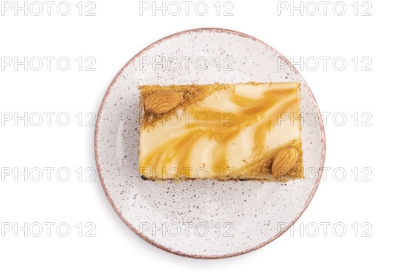 Honey cake with milk cream, caramel, almonds isolated on a white background. Top view, flat lay,