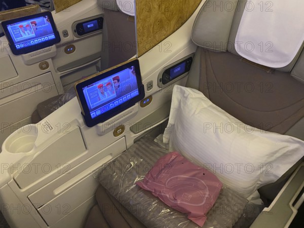 Interior view of Business Class seat with infotainment system, Boeing 777, Emirates airline,