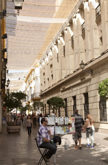 Fabric spread over buildings to provide shade in busy shopping street called Velazquez in central