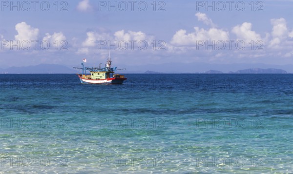 Blue sea and a small fishing boat. Malaysia