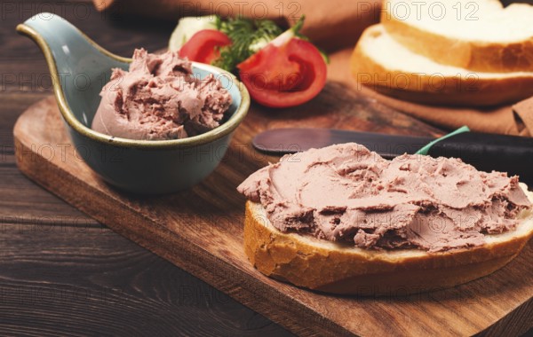 Liver meat pate spread, on white bread, on a wooden background, breakfast, close-up, no people,