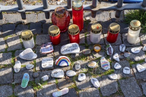 Candles and stones with inscriptions in memory of the dead of the corona pandemic, stickers from