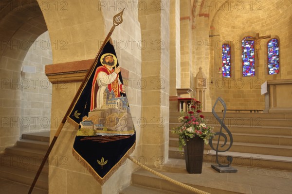 Interior view of the Romanesque basilica of St. Lubentius, chancel with flag of St. Lubentius,