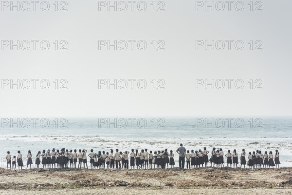 Large school class, children in school uniform and teacher on the beach, Fort Cochin, Kochi,