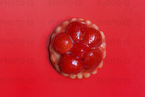 Strawberry tartlets on a red background, fruit cake