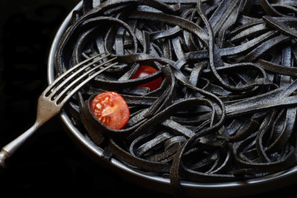 Black pasta coloured with squid ink on a plate, Taglioni al Nero di Seppia, Italy, Europe