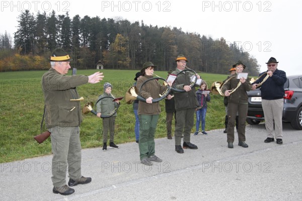 Hunting guide and hunting horn player in front of the start of the hunt for brown hare (Lepus