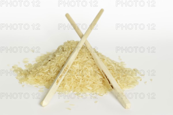 Rice (Oryza sativa), rice grains and chopsticks on a white background