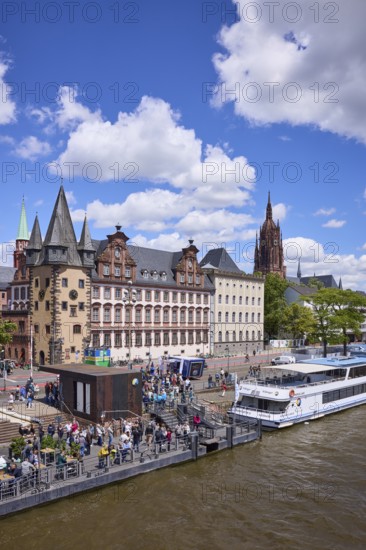 Saalhof with rent tower and excursion boats at the Mainkai under a blue sky with cumulus clouds in