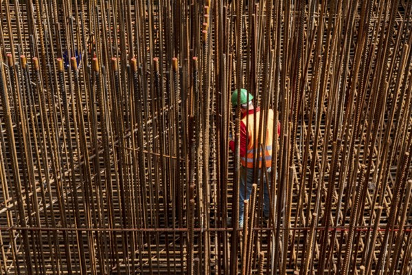 Construction site, reinforced concrete construction site, workers erect a mesh of reinforcing bars,