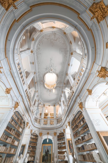 Old library with high ceilings, golden decorations and white walls that creates a calm atmosphere,