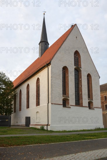 Gothic church with red tiled roof and high tower under a cloudy sky, St Augustin's Monastery
