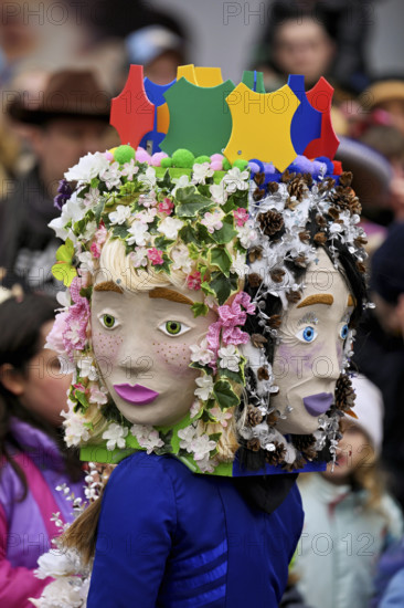 Person masked as a flower girl at the carnival parade of the Wey guild on Rose Monday, Güdismäntig,
