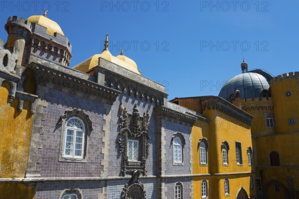 Part of a castle with yellow and grey facades, a dome and windows under a blue sky, Palácio